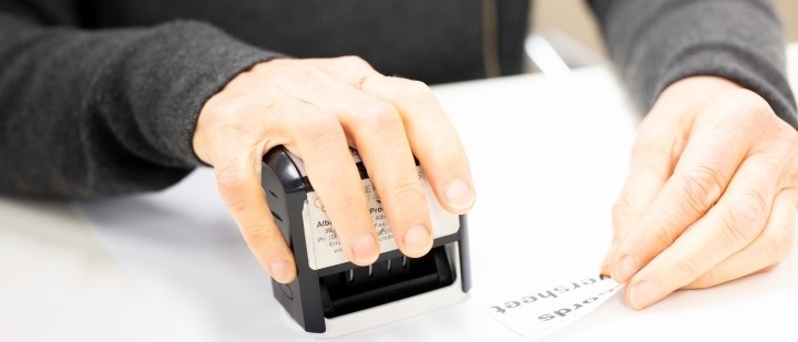 An image of the City of Albany stamping a document