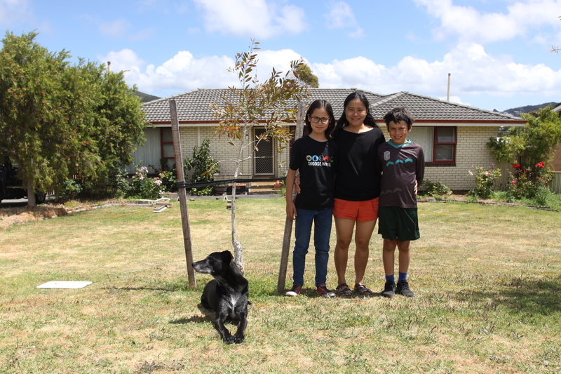 Photo of Family outside of their home with a Street Tree